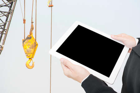 hand hold computer tablet on construction site background