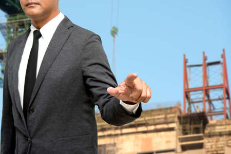 business man showing hand and finger with construction picture backgroundの写真素材