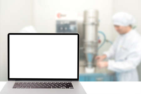 computer with blank screen and blur picture of pharmacy lab in backgroundの写真素材