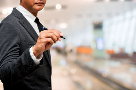 businessman holding pen with blur backgroundの写真素材