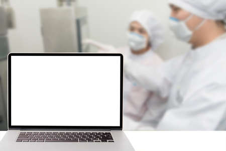computer with blank screen and blur picture of pharmacy lab in backgroundの写真素材