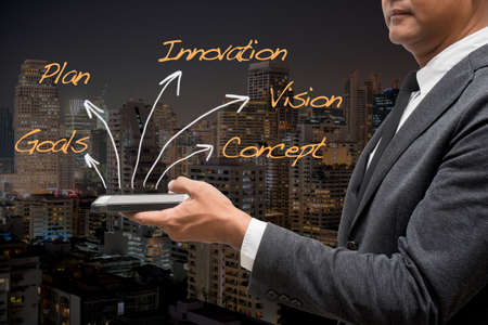 business man standing with black background and words with arrowsの写真素材