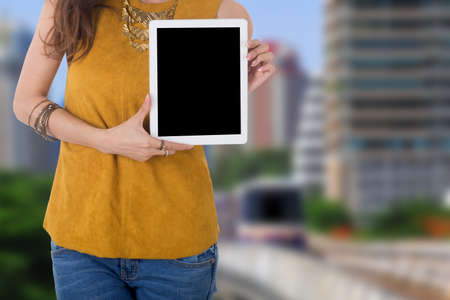 business woman hold computer tablet with city in backgroundの写真素材