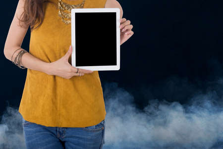 business woman hold computer tablet with smoke in backgroundの写真素材