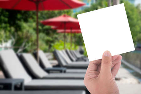 hand hold blank card on red umbrella and pool bedの写真素材