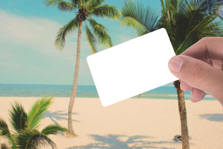 hand hold blank card on picture of coconut tree on the beach apply retro color filterの写真素材