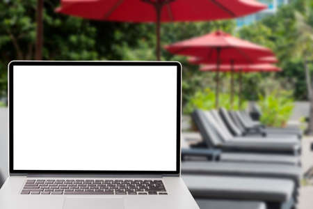 rcomputer with blank screen on picture of red umbrella and pool bedの写真素材