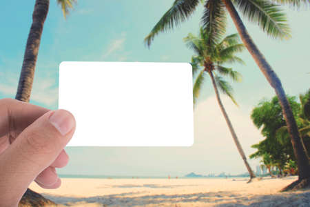 hand hold blank card on picture of coconut tree on the beach apply retro color filterの写真素材