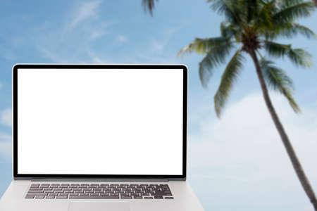 computer with blank screen on picture of coconut tree on the beachの写真素材