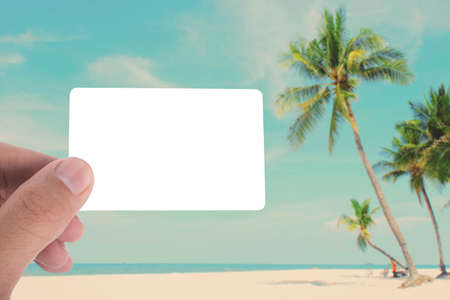 hand hold blank card on picture of coconut tree on the beach apply retro color filterの写真素材