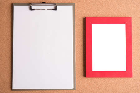 clipboard and blank frame on wooden tableの写真素材