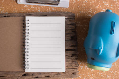 blank note book on table with piggy bankの写真素材