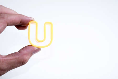 hand hold plastic alphabet Uの写真素材