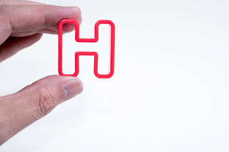 hand hold plastic alphabet Hの写真素材