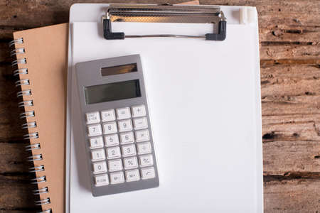 clipboard with blank paper and calculator on  wood tableの写真素材