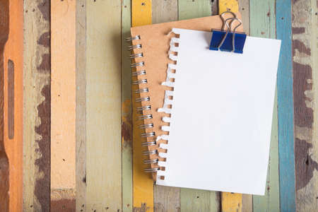 torn paper with clipper on colorful wooden tableの写真素材