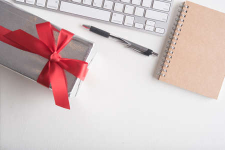 gift box with red ribbon on white office tableの写真素材
