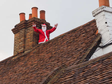 Cookham, UK - December 7 2014: Santa Claus seen on old rooftop at Cookham Christmas street market.のeditorial素材