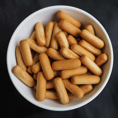 Delicious bread sticks in white bowl