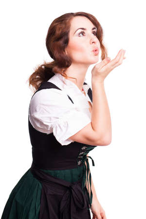 attractive young girl in a dirndl kissing through the air の写真素材