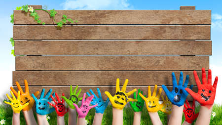 happy children hands in front of wooden sign の写真素材