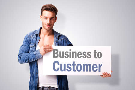young man holding a sign with the slogan \"business to customer\"の写真素材