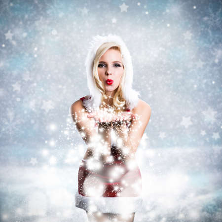 attractive blonde miss santa blowing snowの写真素材