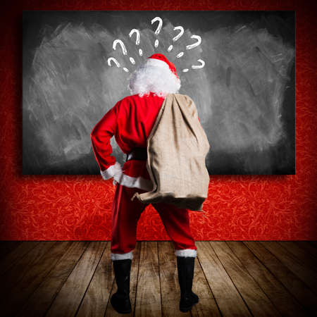 Santa Claus looking at a blackboardの写真素材