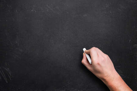 Hand with chalk, starting to writeの写真素材