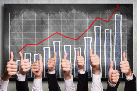 thumbs up to a rising diagramの写真素材