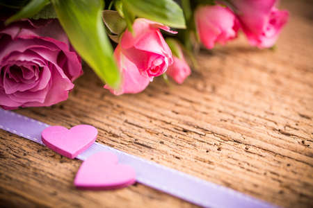 two hearts in front of a bouquet of rosesの写真素材