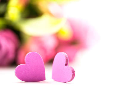two hearts in front of a bouquet of roses