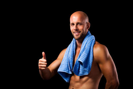 muscular man after workout with thumb up gestureの写真素材