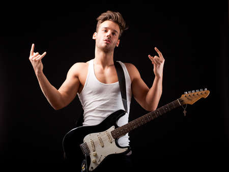 attractive man with a guitar on black backgroundの写真素材