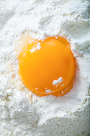 Broken egg on flour, means for making breadの写真素材