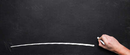 empty blackboard with a hand starting to write