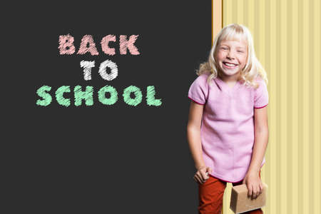 young girl in front of a blackboard with the sentence Back to School