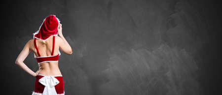 miss santa standing in front of an empty blackboardの写真素材