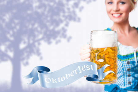 beautiful woman in a traditional bavarian dirndl with a beerの写真素材