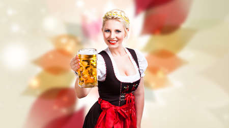 beautiful woman in a traditional bavarian dirndl with a beerの写真素材