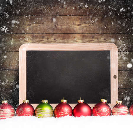 christmas balls with empty chalkboard in the snowの写真素材