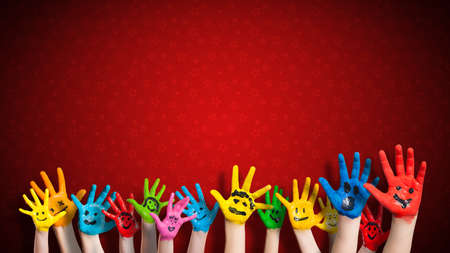 painted children hands with smiley in front of christmas backgroundの写真素材