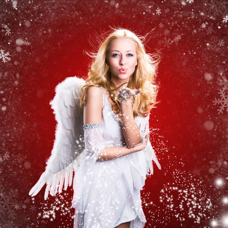 attractive blonde angel and snowflakes with christmas backgroundの写真素材