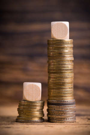 stacked coins showing income difference proportion between rich and normal incomesの写真素材