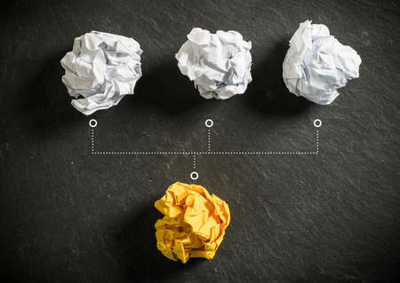 crumpled paper symbolizing different solutions with one standing out with a different color as a...