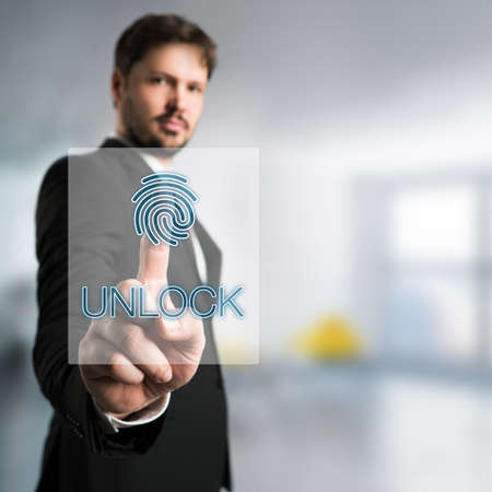 businessman unlocking an interface with his fingerprintの写真素材