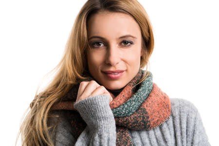 young woman cuddling in her pullover isolated on whiteの写真素材