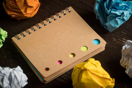 crumpled paper and a notebook on wooden background