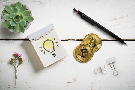 bitcoins with tear-off calendar with idea symbol on wooden background