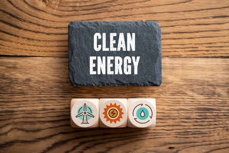 slate plate with message "clean energy" and cubes with related icons on wooden backgroundの写真素材